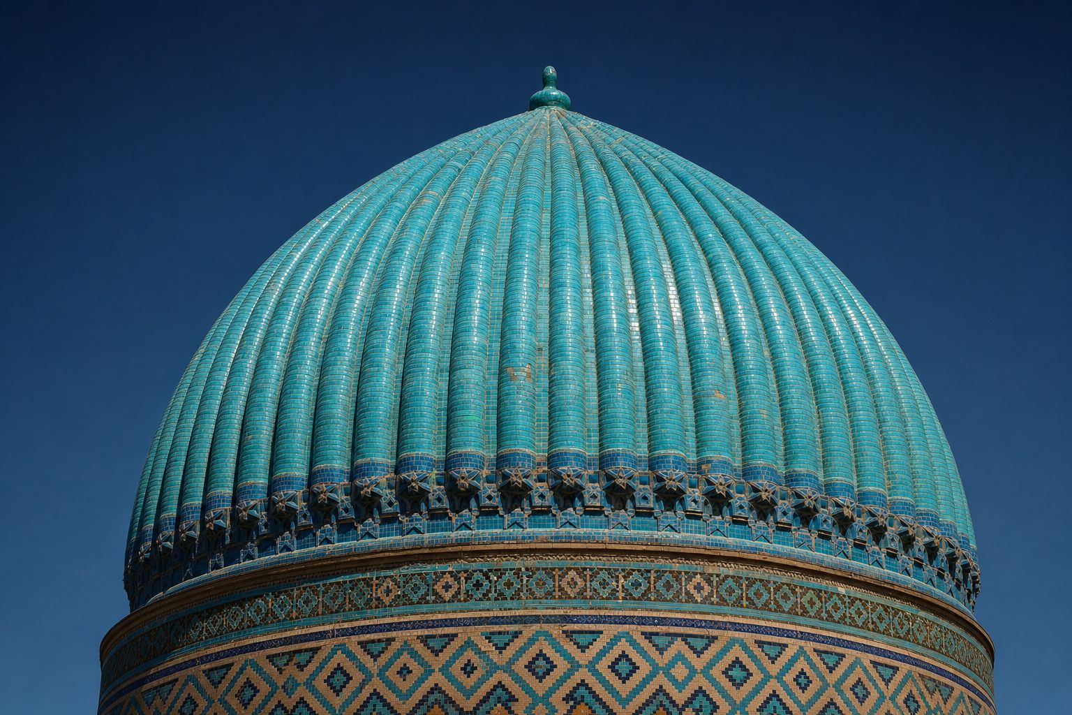 A ribbed melon dome sheathed in turquoise glazed tiles above a band of geometric tilework